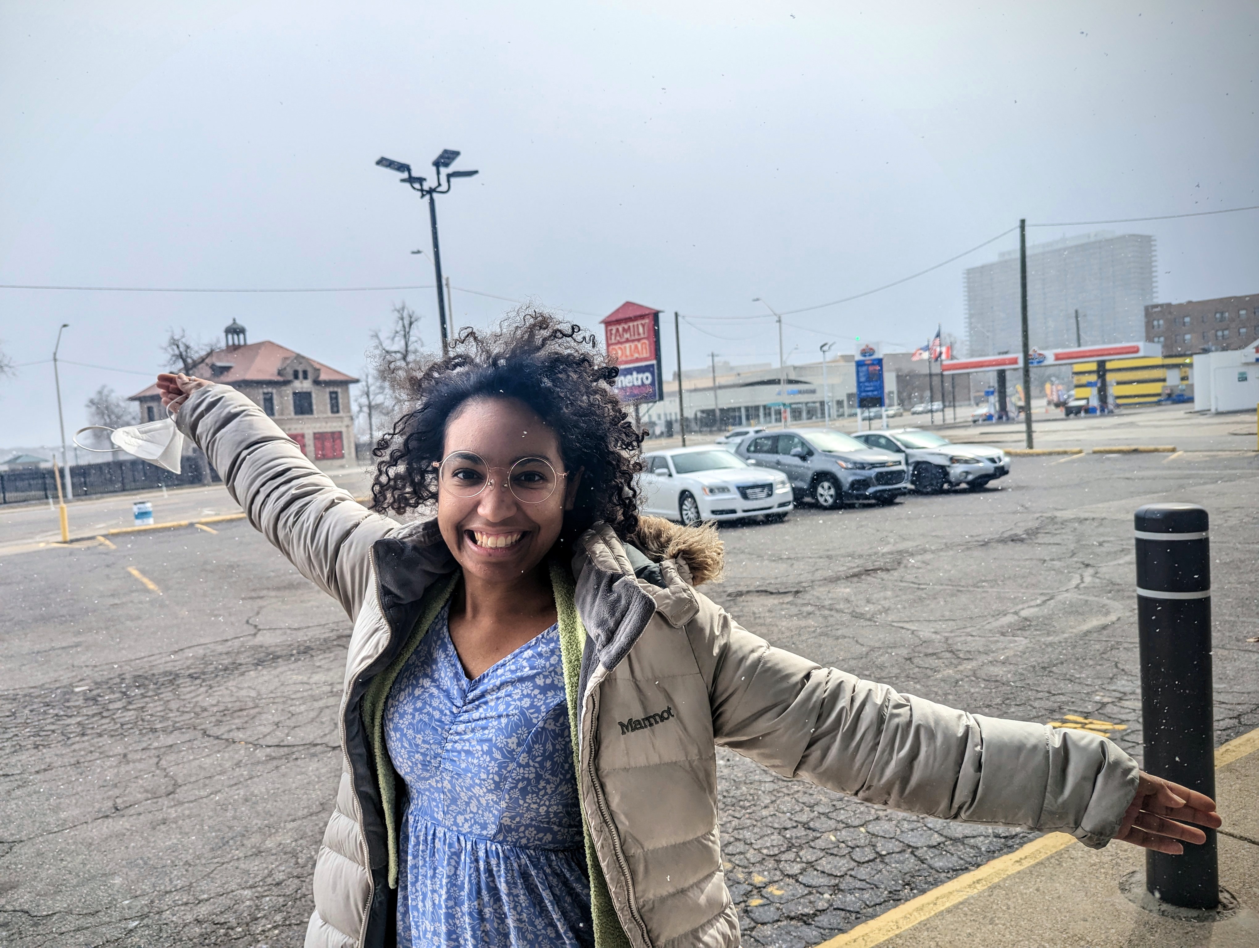 A photo of Karen, a member of Detroit Peer Respite, standing in a parking lot with outstretched arms.